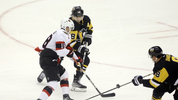 Jan 20, 2022; Pittsburgh, Pennsylvania, USA; Ottawa Senators left wing Tim St tzle (18) skates with the puck against Pittsburgh Penguins defenseman Kris Letang (58) and defenseman Brian Dumoulin (8) during the second period at PPG Paints Arena. The Penguins won 6-4. Mandatory Credit: Charles LeClaire-USA TODAY Sports